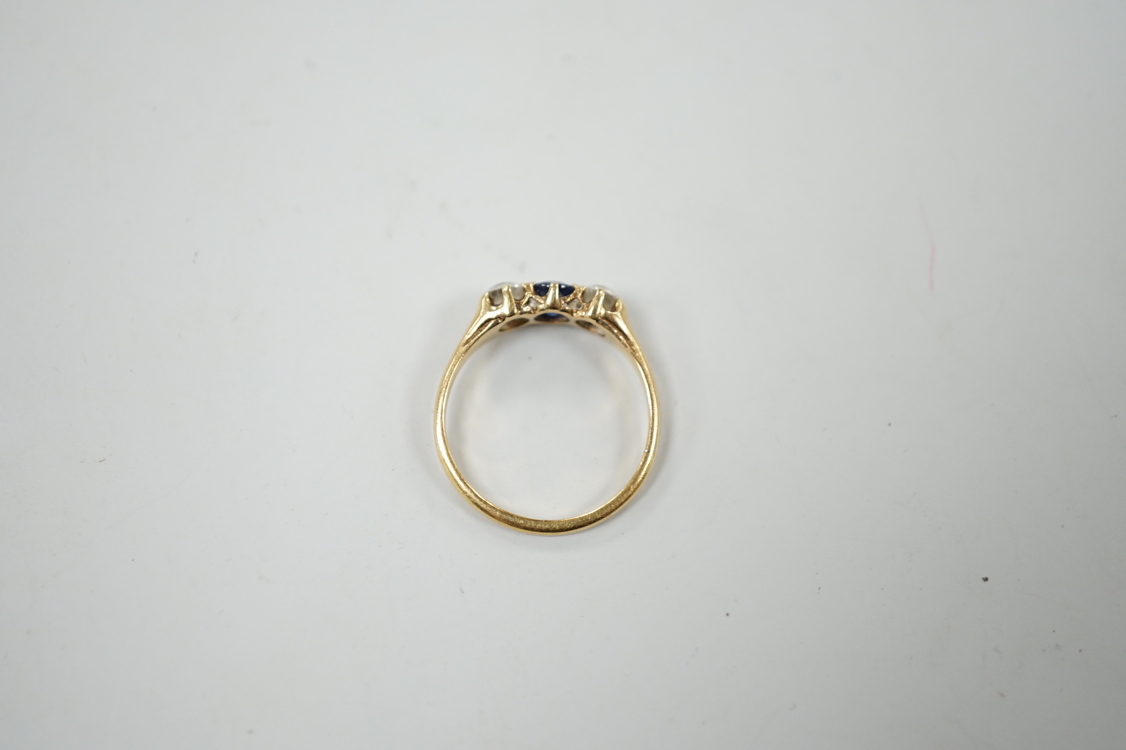 A yellow metal, single stone sapphire and two stone diamond set ring, size L, gross weight 2.3 grams.